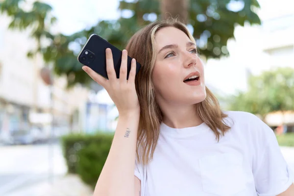 Jovem Caucasiana Sorrindo Confiante Ouvir Mensagem Áudio Pelo Smartphone Rua — Fotografia de Stock