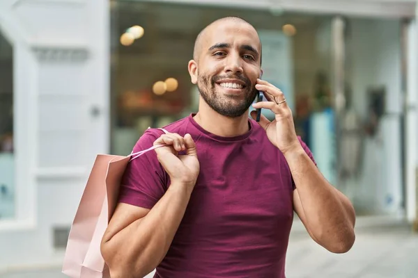 Young Latin Man Talking Smartphone Holding Shopping Bag Street — Stok fotoğraf