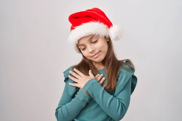 Küçük Beyaz Kız Noel Şapkası Takıyor Elleri Göğsünde Gülümsüyor Gözleri — Stok fotoğraf