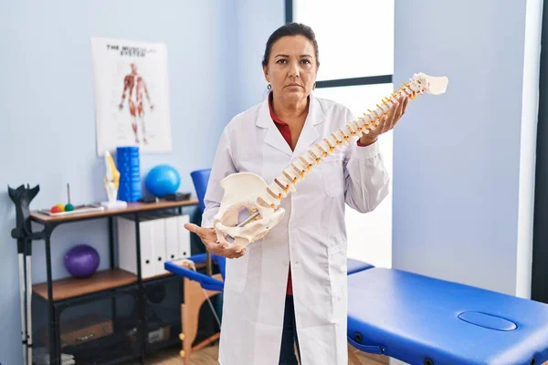 Medelåldern Hispanic Kvinna Håller Anatomisk Modell Ryggraden Skeptisk Och Nervös — Stockfoto