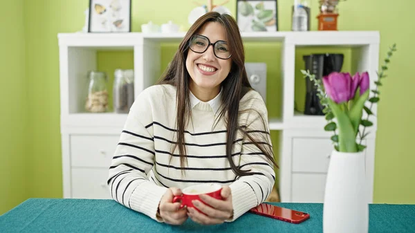 Joven Hermosa Mujer Hispana Sonriendo Confiada Sosteniendo Taza Café Comedor — Foto de Stock