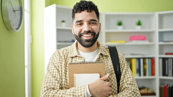Joven Estudiante Hispano Sonriendo Confiado Sosteniendo Cuadernos Universidad Biblioteca —  Fotos de Stock