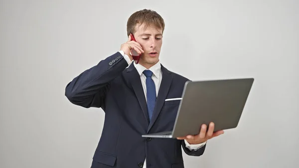 年轻的高加索男性商人使用笔记本电脑在孤立的白色背景下通过智能手机交谈 — 图库照片