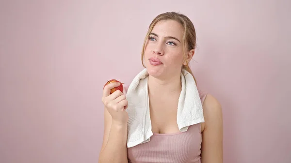 Junge Blonde Frau Sportkleidung Isst Apfel Über Isoliertem Rosa Hintergrund — Stockfoto