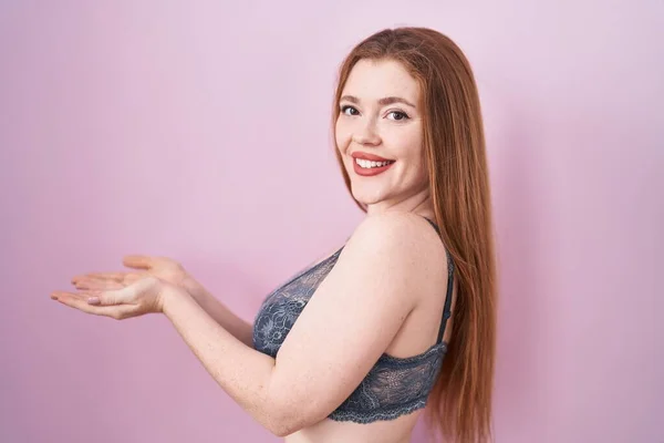 Mujer Pelirroja Vistiendo Lencería Sobre Fondo Rosa Señalando Lado Con — Foto de Stock