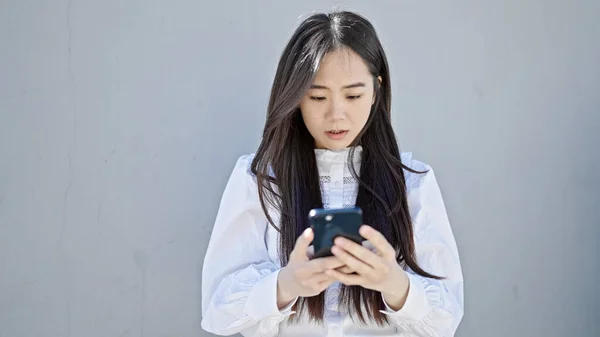 Jonge Chinese Vrouw Met Behulp Van Smartphone Met Ernstige Expressie — Stockfoto