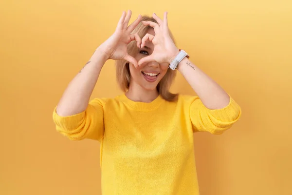 Sarı Süveter Giyen Elleri Parmaklarıyla Kalp Şeklinde Gülümseyen Beyaz Bir — Stok fotoğraf