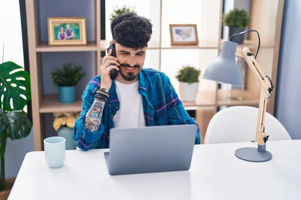 Genç Spanyol Adam Dizüstü Bilgisayar Kullanıyor Evde Akıllı Telefonla Konuşuyor — Stok fotoğraf