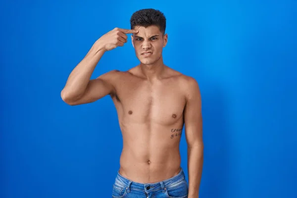Joven Hombre Hispano Pie Sin Camisa Sobre Fondo Azul Señalando —  Fotos de Stock