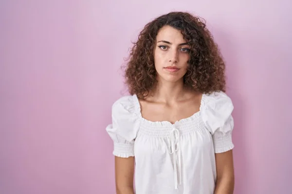 Hispanic Woman Curly Hair Standing Pink Background Relaxed Serious Expression — Foto de Stock