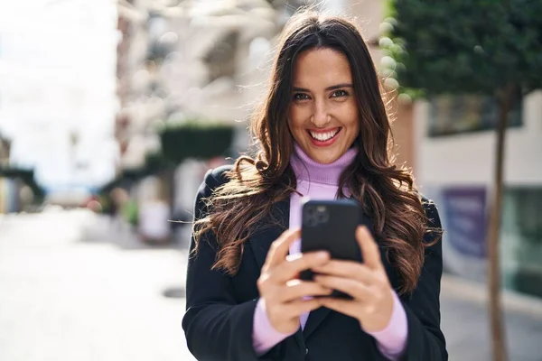年轻的惊慌失措的女人在街上用智能手机充满自信地微笑 — 图库照片