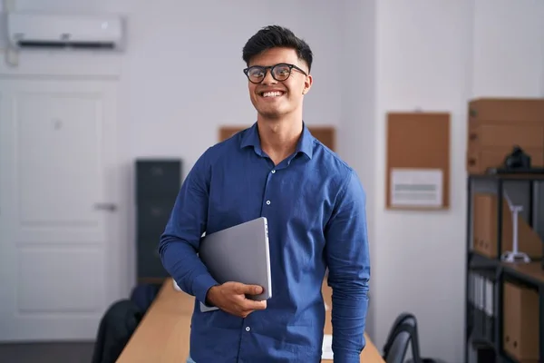 Young Hispanic Afaceri Lucrător Zâmbind Încrezător Deține Laptop Birou — Fotografie, imagine de stoc