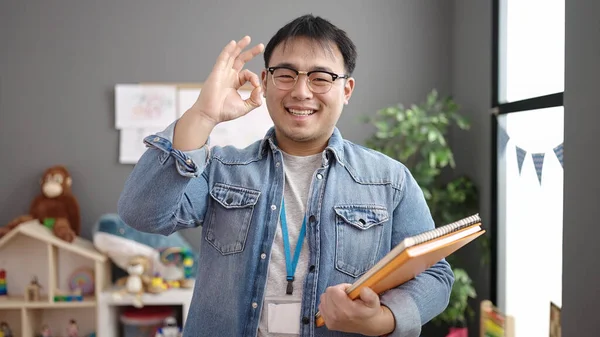 Молодой Китайский Учитель Держит Книги Руках Хорошо Жестикулирует Детском Саду — стоковое фото