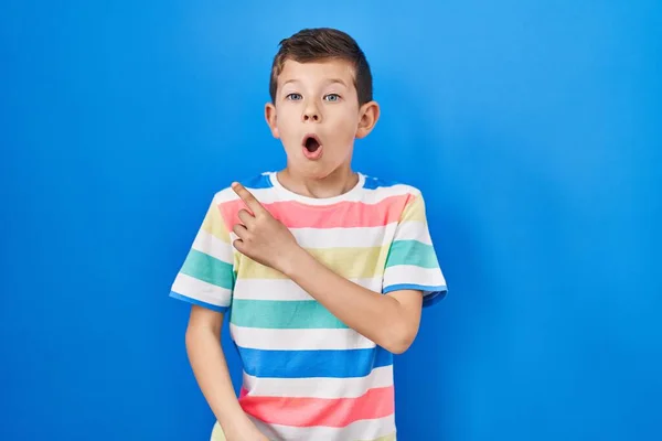 Jovem Caucasiano Criança Sobre Fundo Azul Surpreso Apontando Com Dedo — Fotografia de Stock