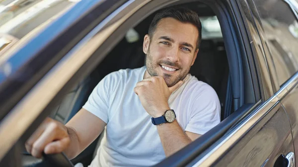 若いヒスパニック系の男が自信を持って路上で車の上に座って笑って — ストック写真