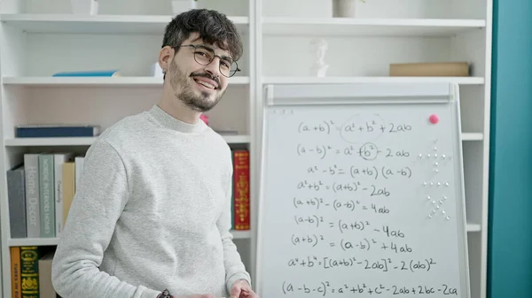 Young hispanic man teacher teaching maths lesson at university classroom