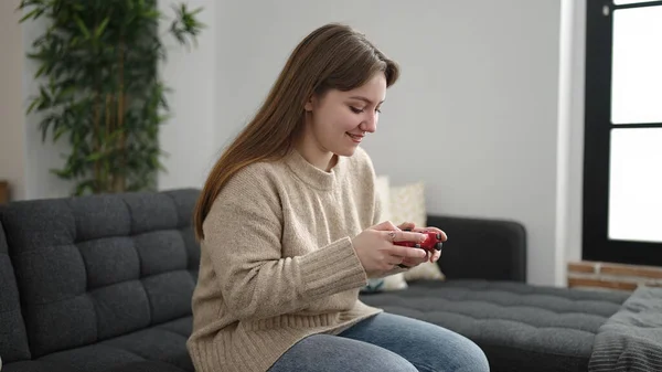 Young Blonde Woman Playing Video Game Sitting Sofa Home — Fotografia de Stock
