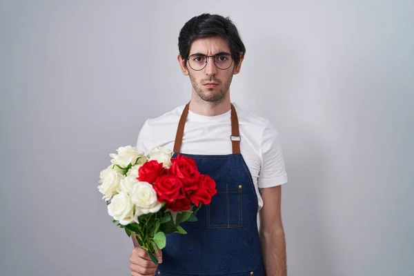 Joven Hombre Hispano Sosteniendo Ramo Rosas Blancas Rojas Escéptico Nervioso —  Fotos de Stock