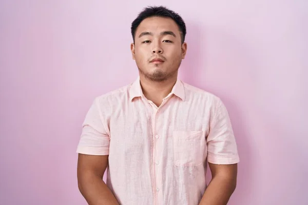 Китайский Молодой Человек Стоящий Розовом Фоне Расслабленный Серьезным Выражением Лица — стоковое фото