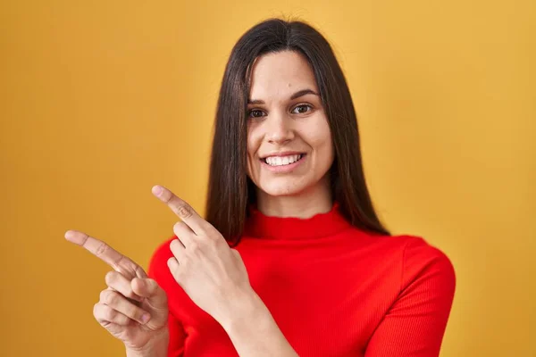 Young Hispanic Woman Standing Yellow Background Smiling Looking Camera Pointing — Foto de Stock