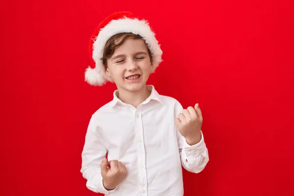 Little Caucasian Boy Wearing Christmas Hat Red Background Celebrating Surprised — Stock Photo, Image