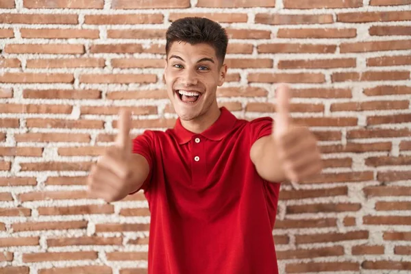 Jovem Hispânico Sobre Tijolos Parede Aprovando Fazer Gesto Positivo Com — Fotografia de Stock