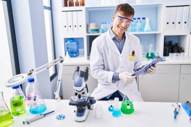 Genç bilim adamı gülümsemesi Laboratuvarda kendine güvenen okuma raporu