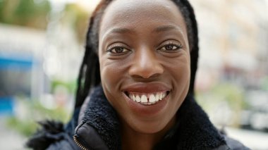 Sokakta kendine güvenen Afrikalı Amerikalı kadın gülümsüyor