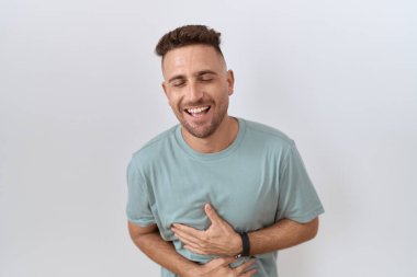 Beyaz arka planda sakallı İspanyol bir adam var. Gülümsüyor ve kahkahalar atıyor.. 