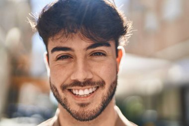 Sokakta kendinden emin gülümseyen İspanyol genç adam.