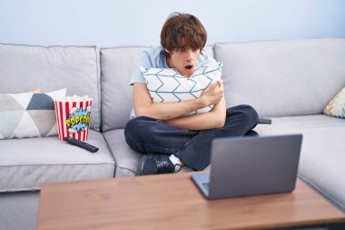 Dizüstü bilgisayarda korku filmi izleyen İspanyol genç adam şaşkınlık ve şaşkınlık dolu bir ifade, korku ve heyecan dolu bir yüz ifadesiyle korkmuş ve şok olmuştu.. 