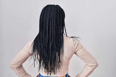 Beyaz arka planda durup kolları vücudunda olan Afrikalı bir kadın. 