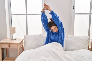 Genç, güzel İspanyol bir kadın yatak odasında kollarını açarak uyanıyor.