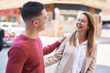 Kadın ve erkek anne ve oğul caddede yan yana duruyorlar.