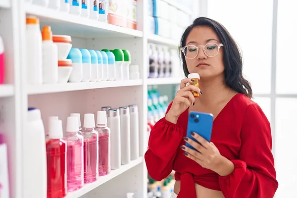 Молодая Китаянка Клиент Помощью Смартфона Держа Бутылку Лекарством Аптеке — стоковое фото