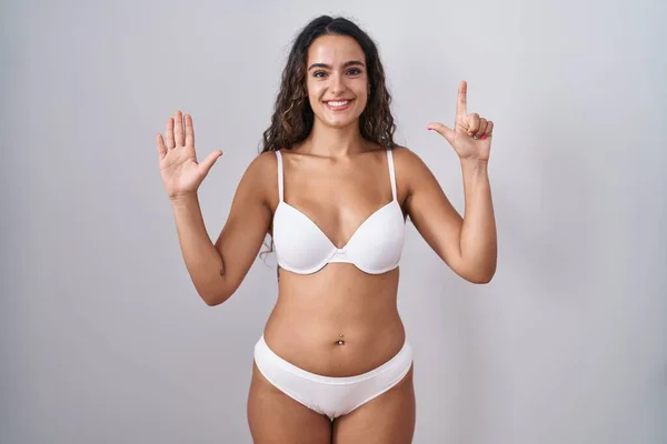 Genç Spanyol Kadın Beyaz Çamaşırı Giyip Yedi Numaralı Parmaklarıyla Işaret — Stok fotoğraf