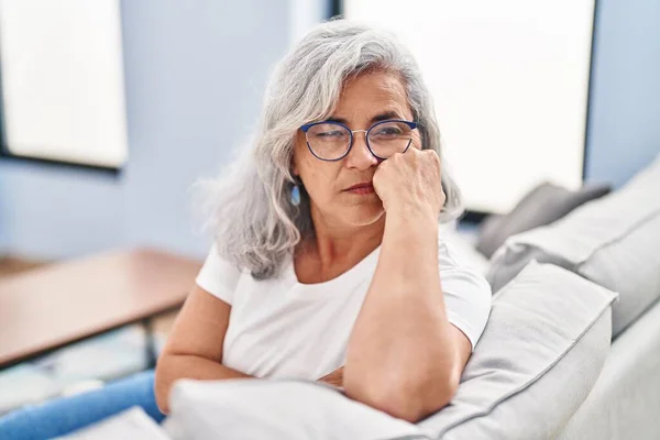 stock image Middle age woman stressed sitting on sofa at home