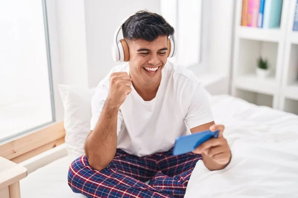 Молодий Іспаномовний Чоловік Посміхається Впевнено Граючи Відеоігри Спальні — стокове фото