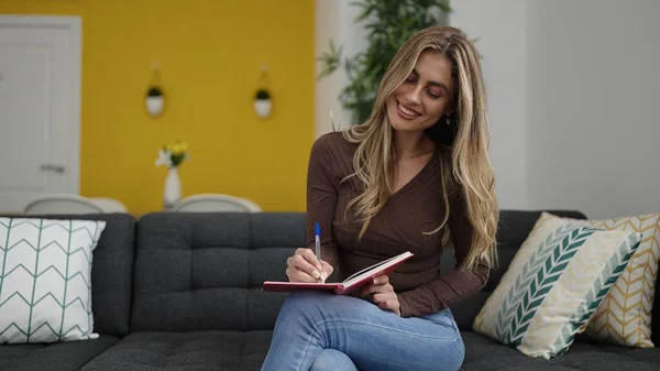 Mujer Rubia Joven Escribiendo Cuaderno Sentado Sofá Casa —  Fotos de Stock