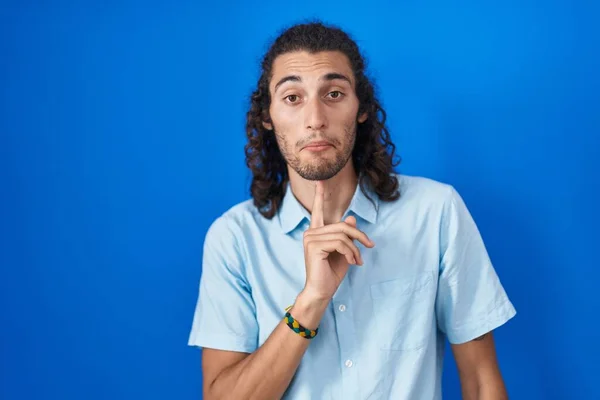 Joven Hombre Hispano Pie Sobre Fondo Azul Pensando Concentrado Duda — Foto de Stock