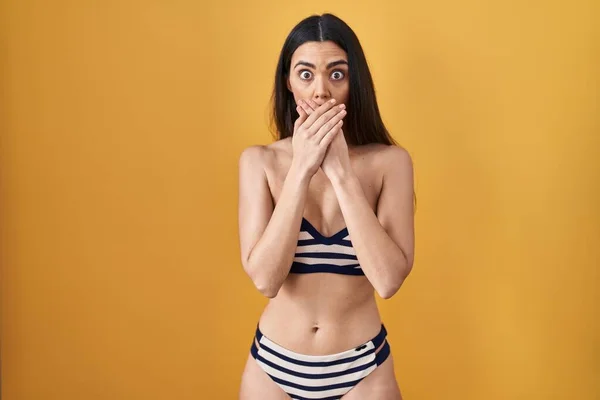 Mujer Morena Joven Con Bikini Sobre Fondo Amarillo Sorprendió Cubriendo — Foto de Stock