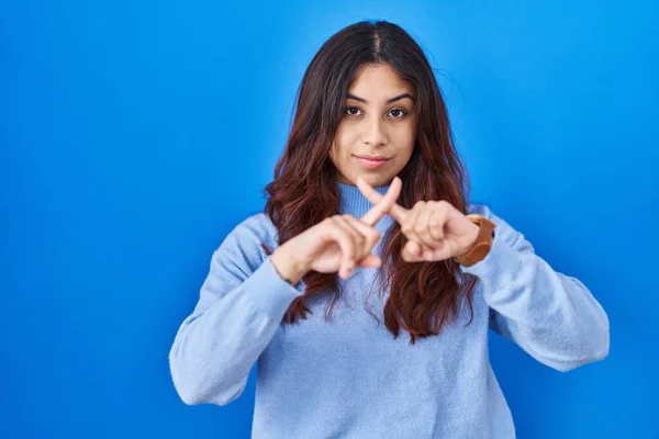 Mulher Jovem Hispânica Sobre Fundo Azul Expressão Rejeição Cruzando Dedos — Fotografia de Stock