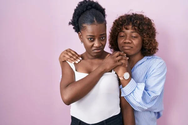 Δύο Αφρικάνες Που Στέκονται Πάνω Από Ροζ Φόντο Σκεπτικές Και — Φωτογραφία Αρχείου
