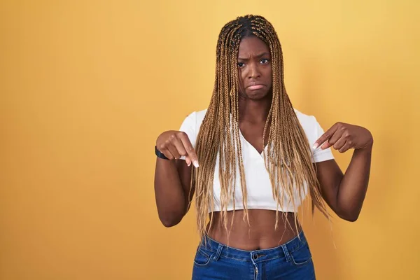 Африканская Американка Плетеными Волосами Стоящая Желтом Фоне Указывая Грустный Расстроенный — стоковое фото