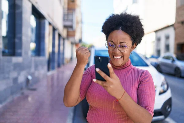ストリートで勝者の表情を持つスマートフォンを使用してアフリカ系アメリカ人女性 — ストック写真