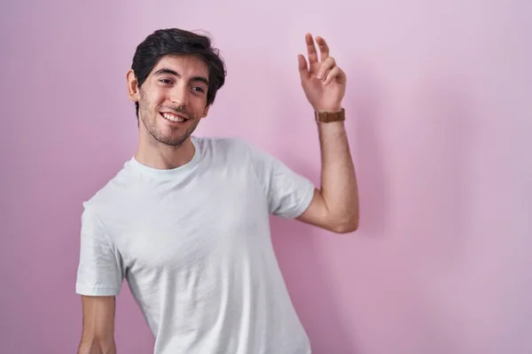 Young Hispanic Man Standing Pink Background Dancing Happy Cheerful Smiling — стоковое фото