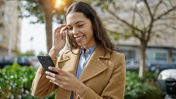 stock image Young beautiful hispanic woman using smartphone smiling at park