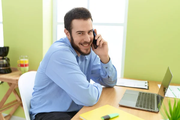 Young Hispanic Man Business Worker Using Laptop Talking Smartphone Office — Zdjęcie stockowe