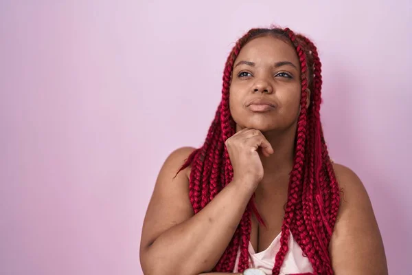 Afroamerykanka Plecionymi Włosami Stojąca Nad Różowym Tłem Ręką Podbródku Myśląca — Zdjęcie stockowe