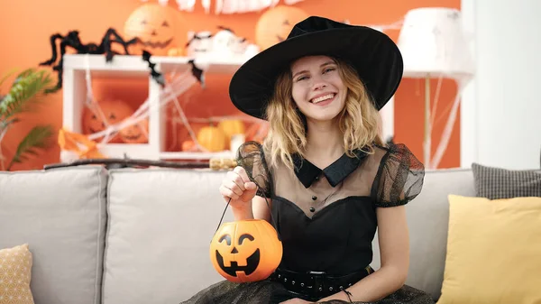 Young Blonde Woman Wearing Halloween Costume Holding Pumpkin Basket Home — стоковое фото